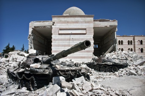 A destroyed Syrian tank sits among rubble in Azaz, Syria. Photo from Wikimedia Commons.