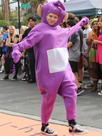 Junior Cheyenne Culp dances down the runway as a Teletubby. “I really liked the show growing up, and Tinky Winky was my favorite Teletubby so I thought it would be a funny costume.” Photo taken by Jakob Woo-Ming.