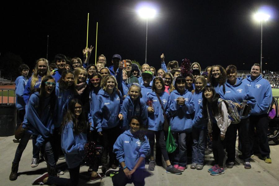 The Coastal Academy ASB team poses in front of the football field, parading in their Dolphin pride.