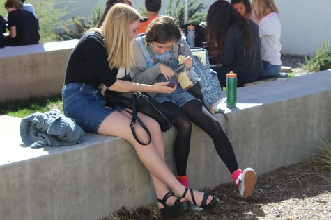 Juniors Natalie Nieman and Brittany Lang laugh about something on the phone during lunch on Thursday.