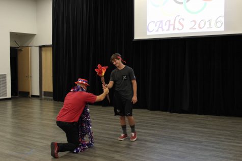 Principal Dana Moen presents the CAHS Olympic Torch to ASB President and senior Jacob Mizel. 