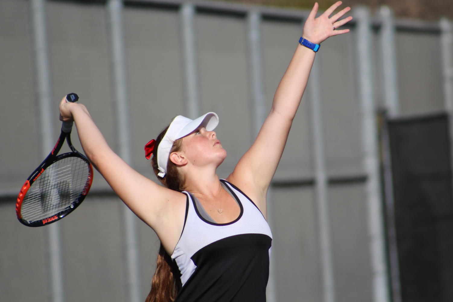Sophomore Taylor Smith attempts a serve at the match against San Diego Jewish Academy. Photo credit Danica Jordan.